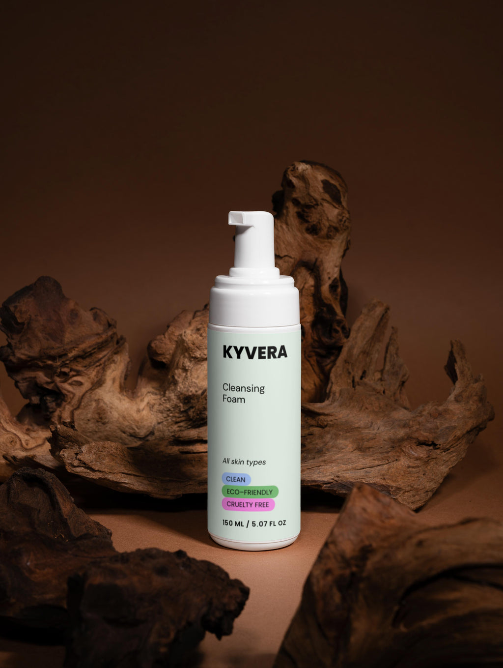 KYVERA Cleansing Foam bottle for gentle face wash against a wood background, promoting clean and fresh skin.