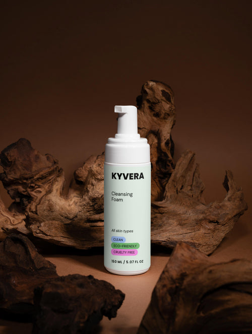 KYVERA Cleansing Foam bottle for gentle face wash against a wood background, promoting clean and fresh skin.