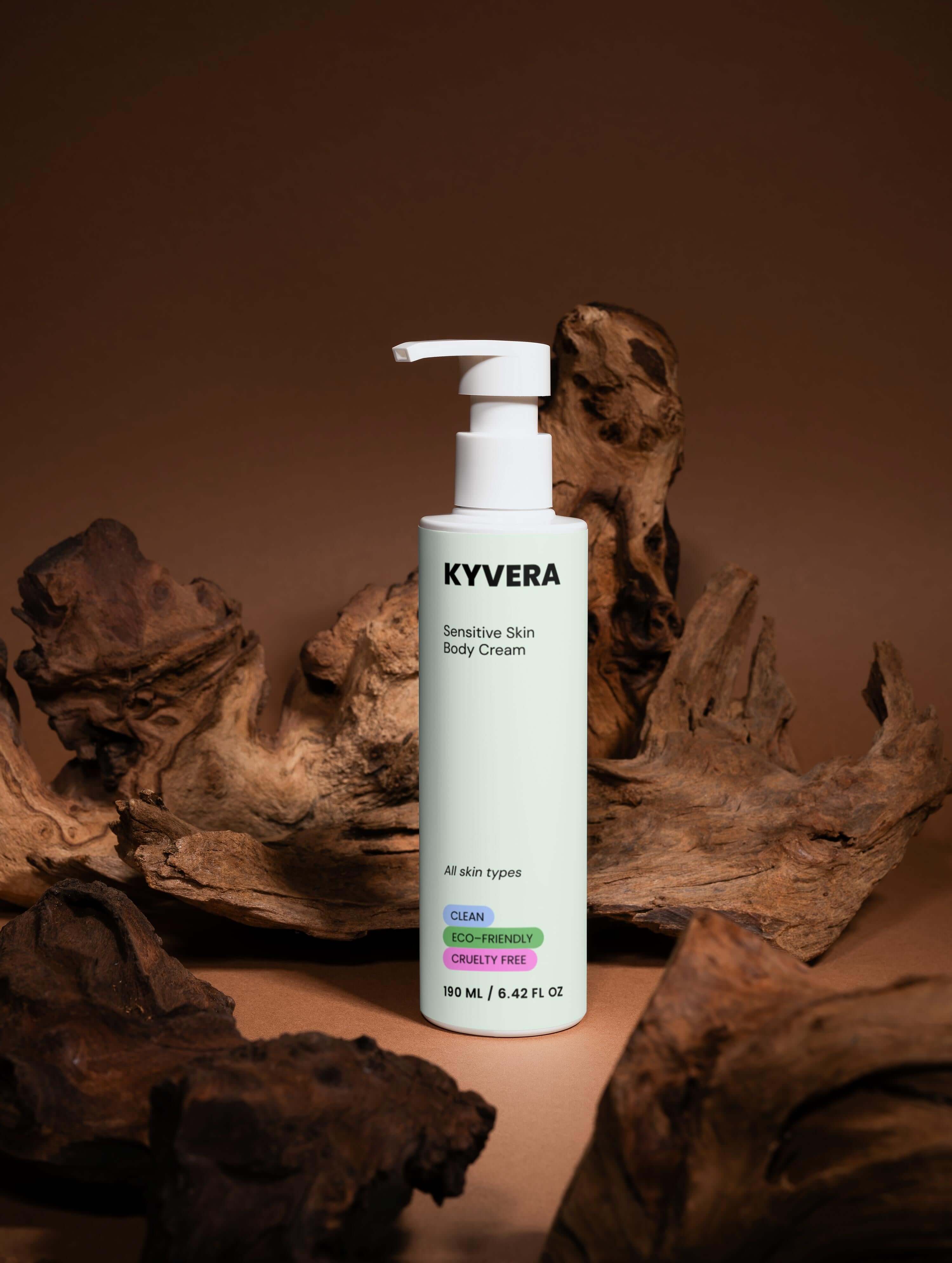KYVERA Sensitive Skin Body Cream bottle on wood background for delicate skin nourishment and hydration.
