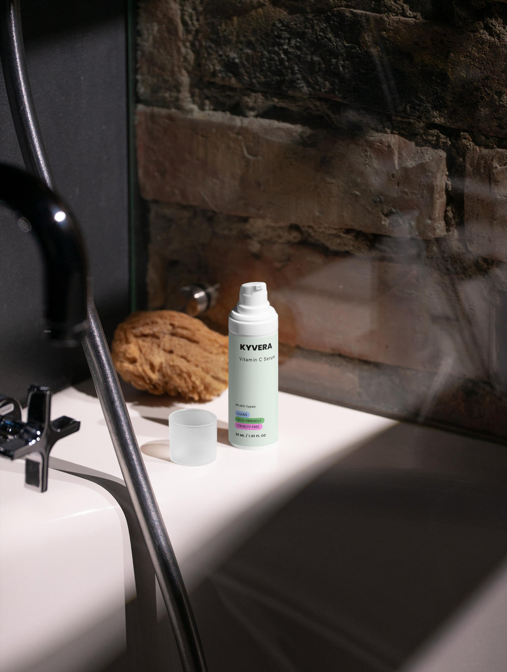 Vitamin C Serum bottle on a bathroom countertop near a natural sponge, promoting radiant and youthful skin.