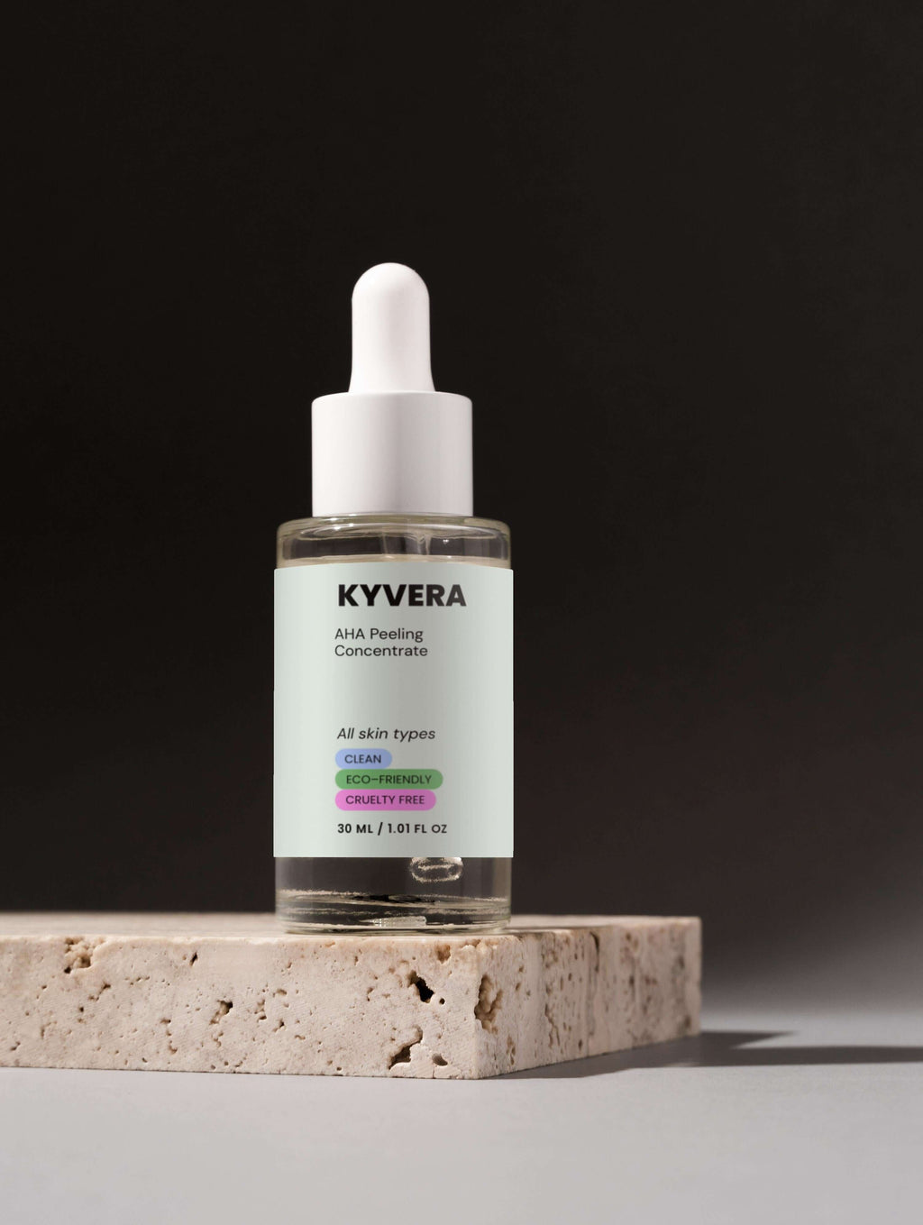 KYVERA AHA Peeling Concentrate in a dropper bottle on a stone surface, promoting radiant skin renewal.